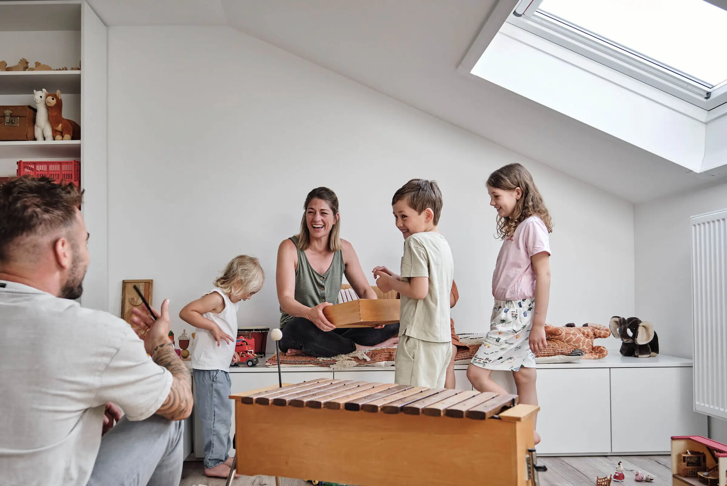 Bannerbild, Familie mit zwei Kindern im Kinderzimmer mit Regal