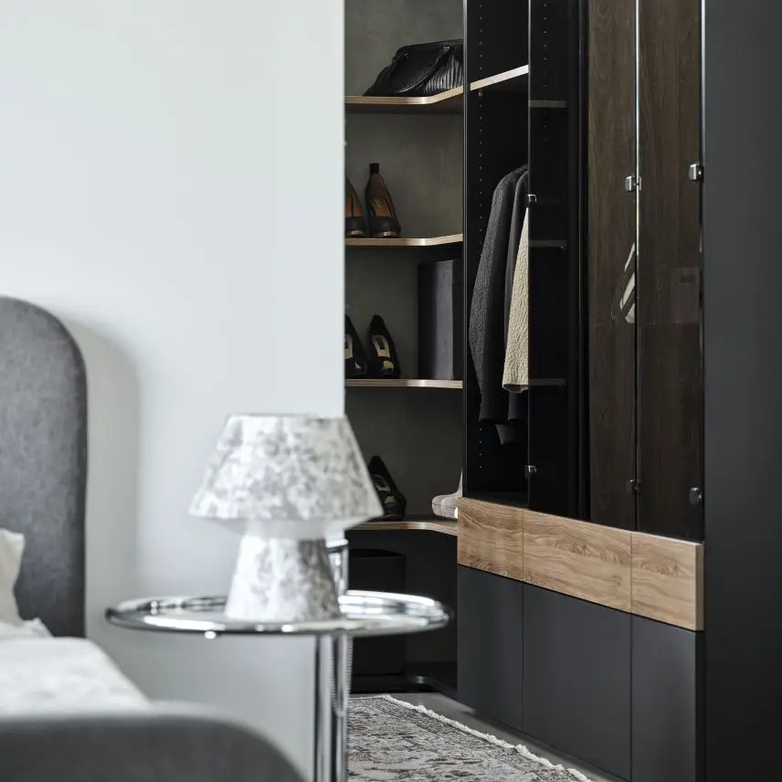 Kleiderschrank in Schwarz steht im Ankleidezimmer