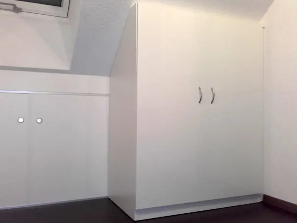 Weisser Dachschrägenschrank mit Schraege nach hinten.