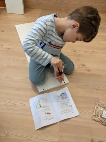 Kind baut Möbel zusammen