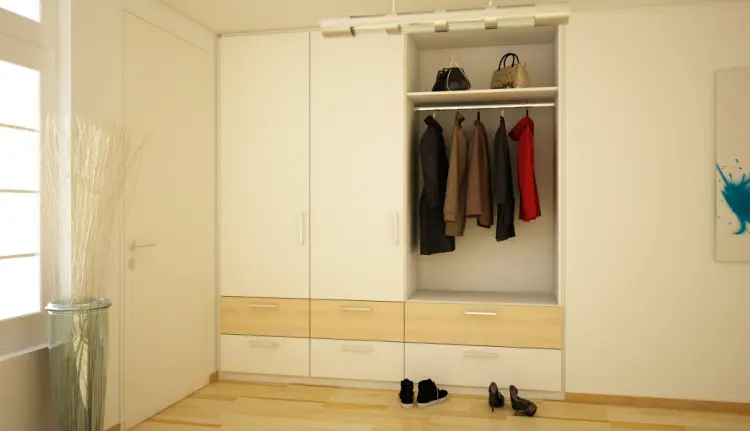 Garderobe in Weiss mit Schubladen in Holzoptik und Kleidung.