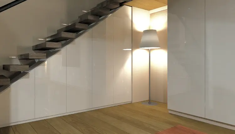 Garderobenschrank in Weiss unter der Treppe und Stehlampe in Weiss.