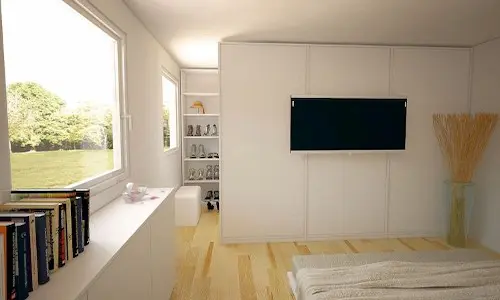Begehbarer Kleiderschrank versteckt hinter TV-Wand.