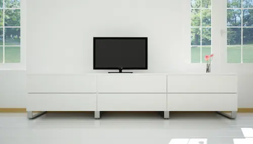 Sideboard in Weiss mit TV in Wohnbereich.