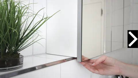 Badezimmerschrank mit Spiegeltür wird geöffnet