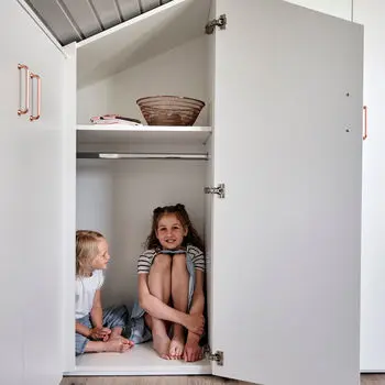 Dachschraegenschrank mit offener Tür und Kinder.