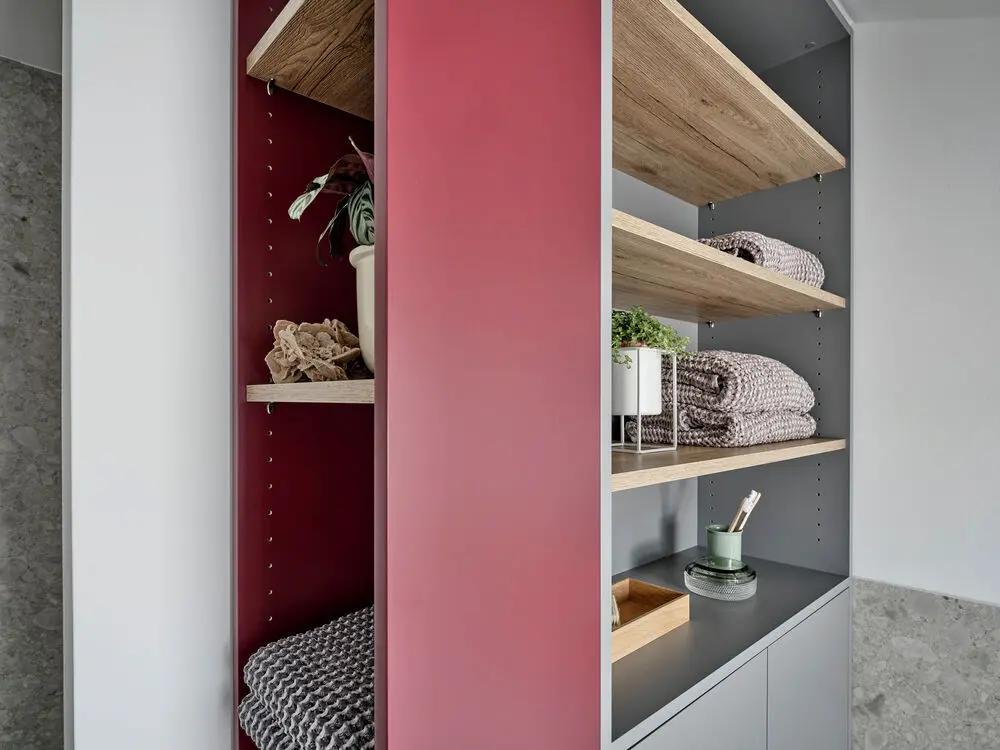 Badezimmerschrank in Grau und Rot mit Dekoration.