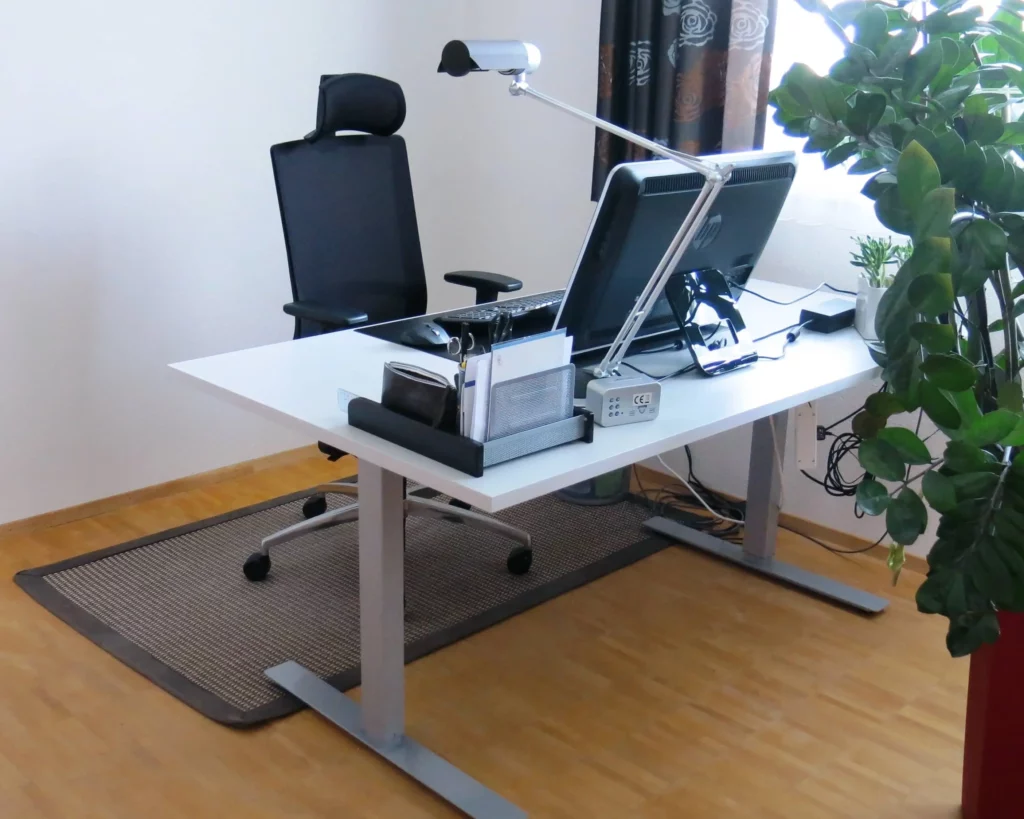 Schreibtisch mit Inventar und Dekoration in Grau.