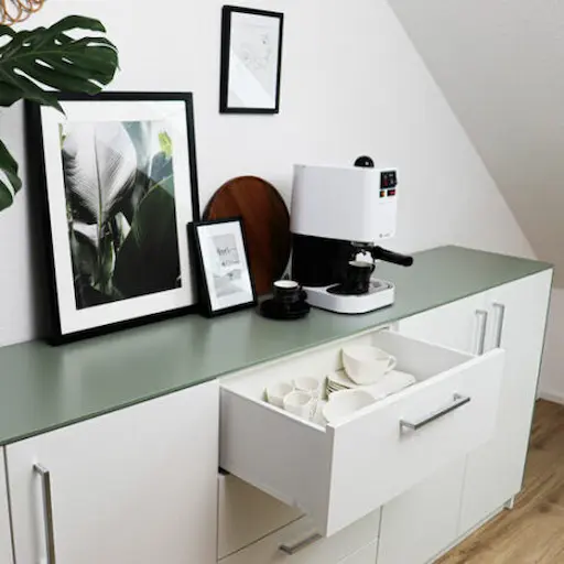 Sideboard mit Abdeckplatte in Mint und Kaffeemaschine.