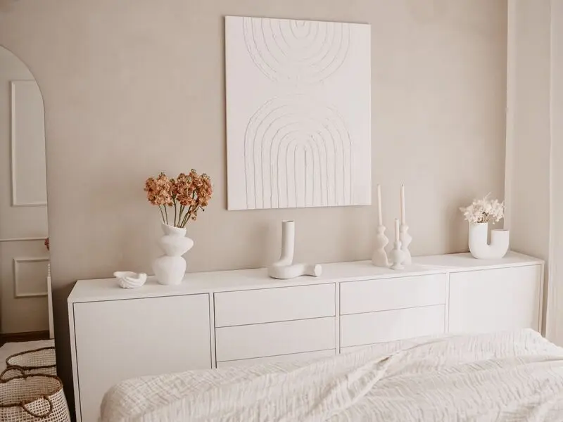 Sideboard in Weiss mit Dekoration im Schlafzimmer.