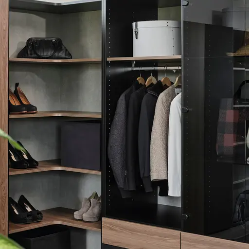 Kleiderschrank mit Bekleidung in Schwarz und Holz.